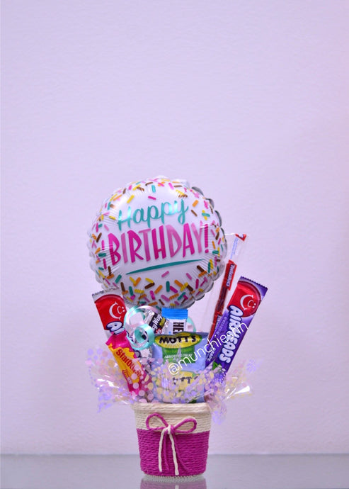 Canasta pequeña rosada con dulces y globo mediano confeti happy birthday